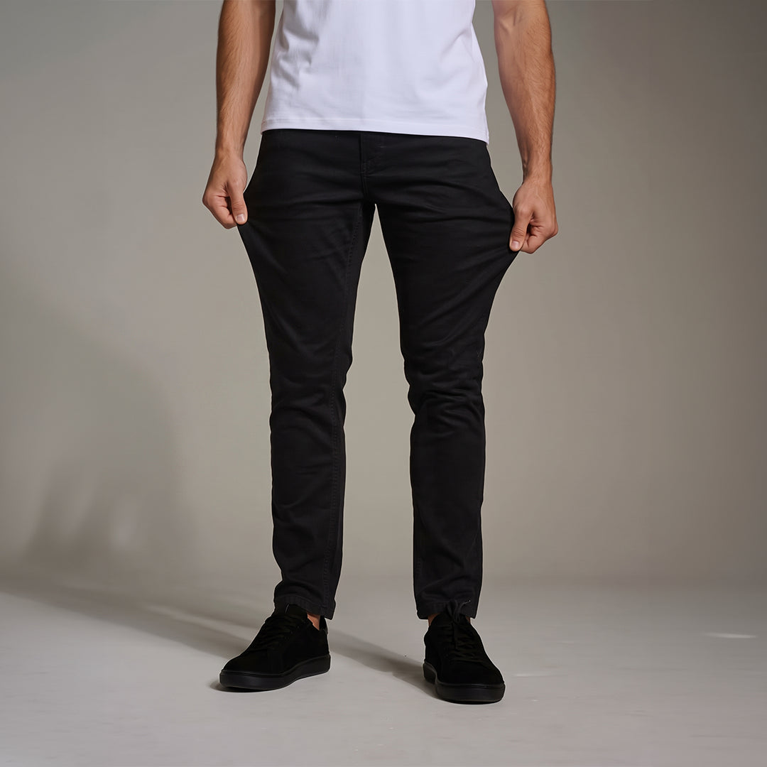 Homem puxando a cintura da Calça Jeans Comfort preta, mostrando o caimento